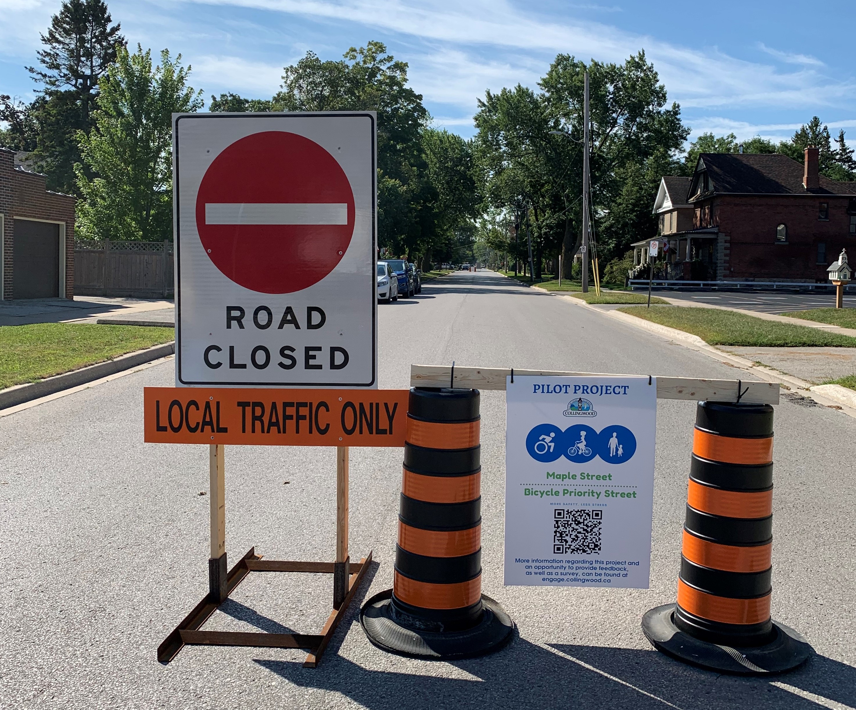 A road closed sign with the pilot project sign beside it. 