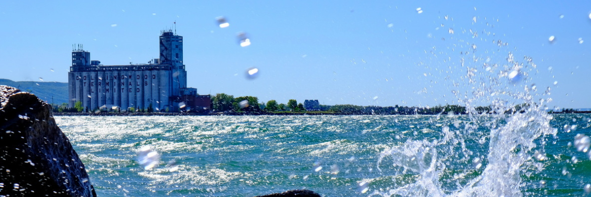 water splashing in foreground, georgian bay in midground and terminals in background