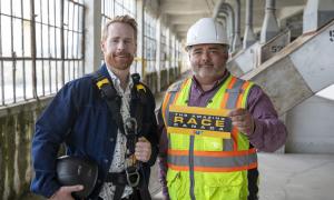 Jon Montgomery, host of The Amazing Race Canada and project manager Adam Gallant holding a clue on the bin floor of the Collingwood Grain Terminals