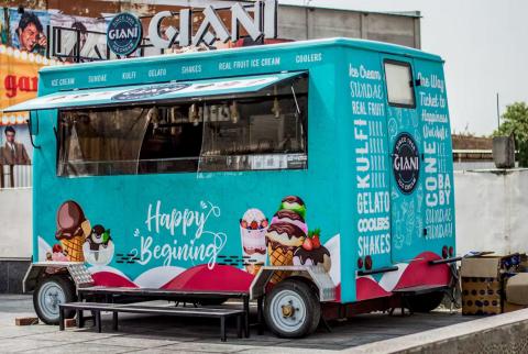 Colourful Giani ice cream truck offering a variety of treats, including gelato, shakes, and sundaes, with playful 'Happy Beginning' signage.